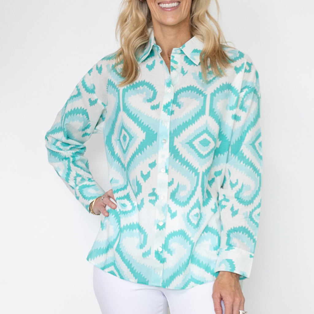 Woman wearing a turquoise and white patterned shirt on a white background