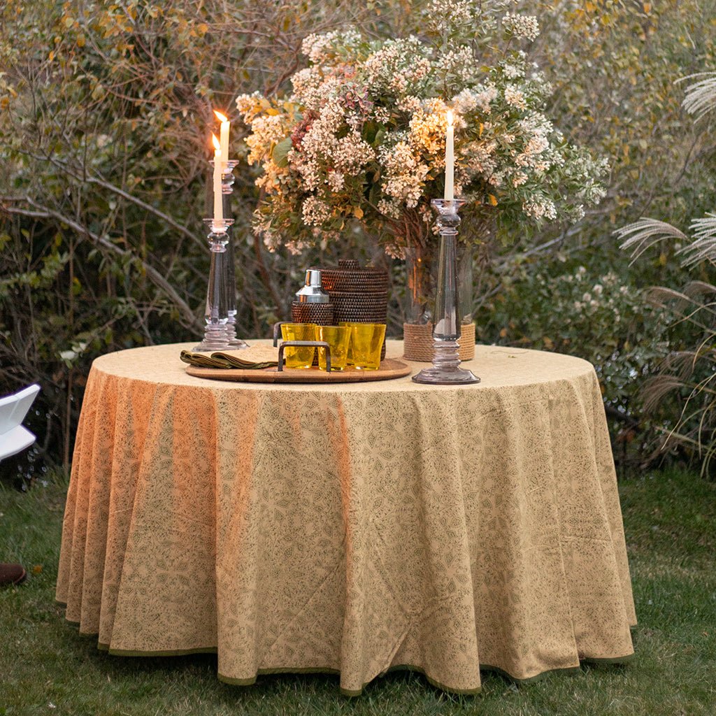 Decorated outdoor table with candles, flowers, and drinks in a garden setting