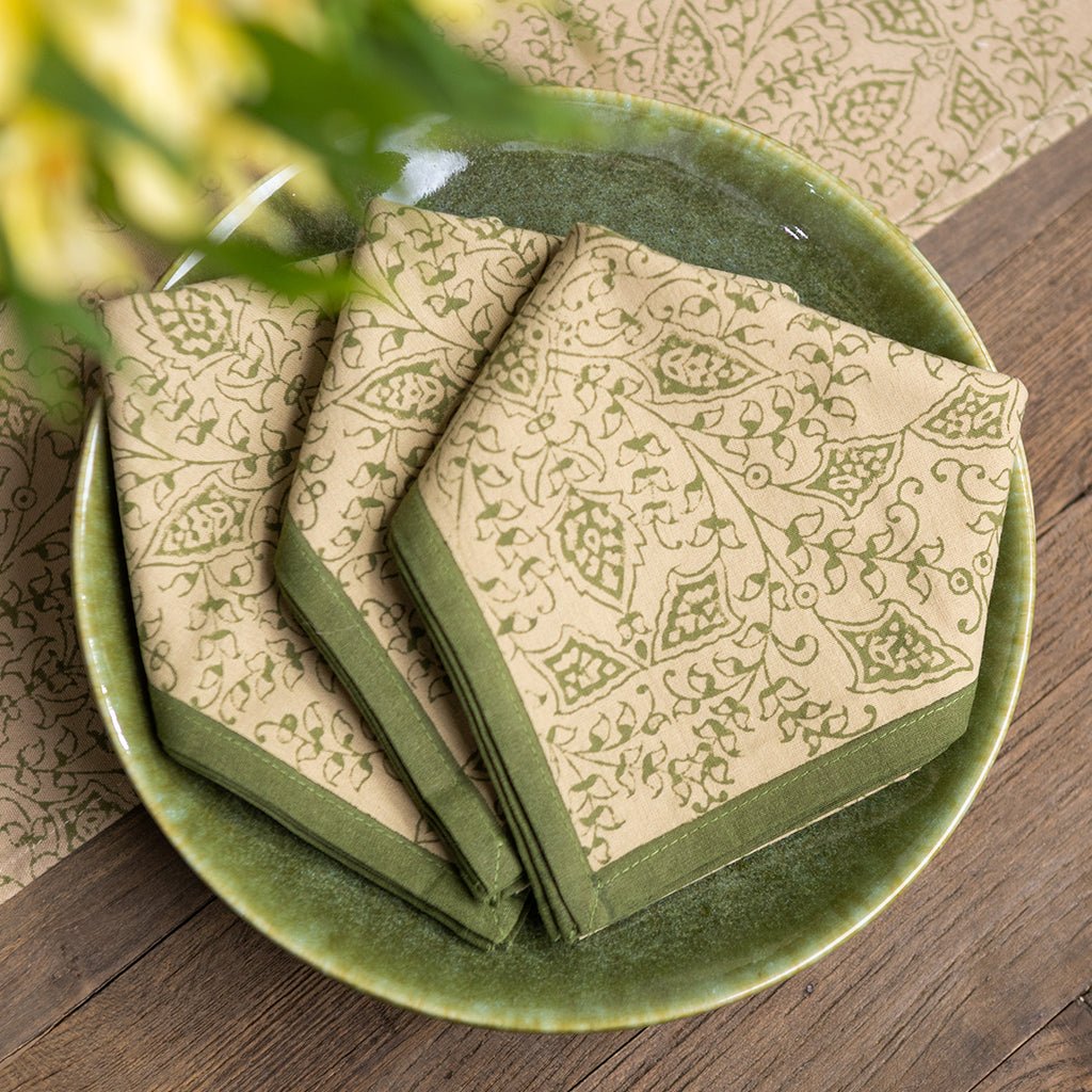 Set of patterned napkins on a green ceramic plate with a wooden background