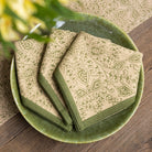 Set of patterned napkins on a green ceramic plate with a wooden background