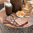 Set of 4 mixed napkins with rattan barware and bourbon glasses.