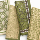 Collection of green and beige patterned napkins on a white background