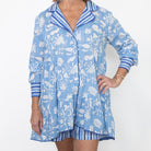 Woman wearing a blue and white patterned shirt with matching shorts on a white background