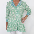 Green floral patterned shirt with striped collar on a white background