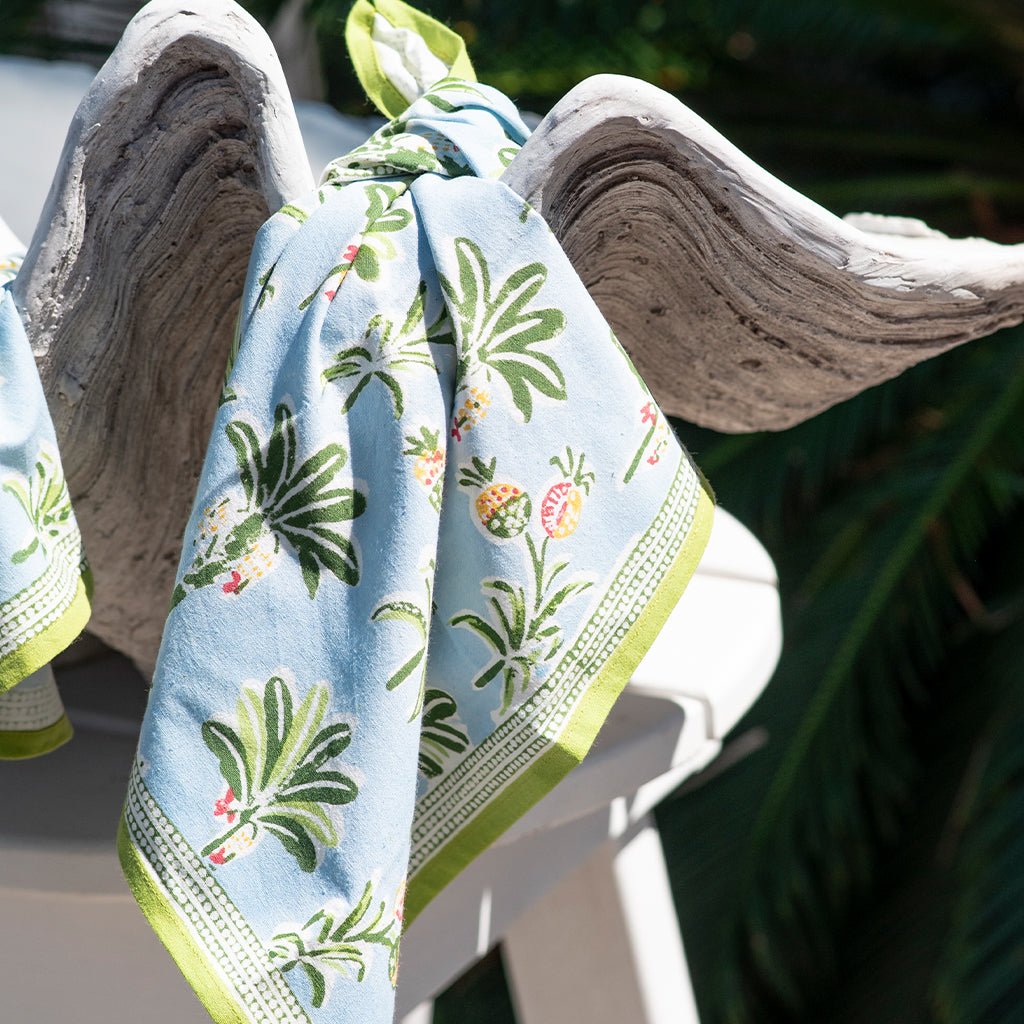 Floral patterned napkin hanging on a bowl with a blurred natural background