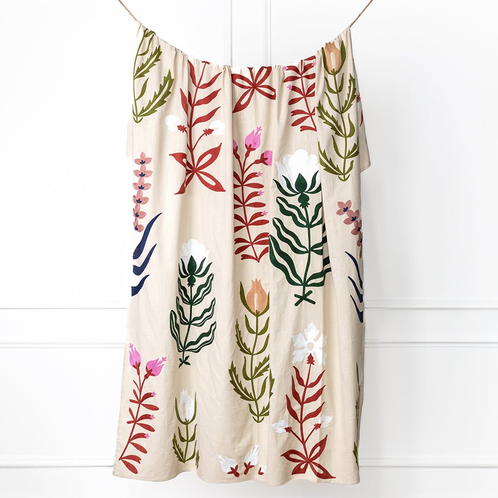 Decorative towel with floral patterns hanging against a white background