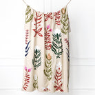 Decorative towel with floral patterns hanging against a white background