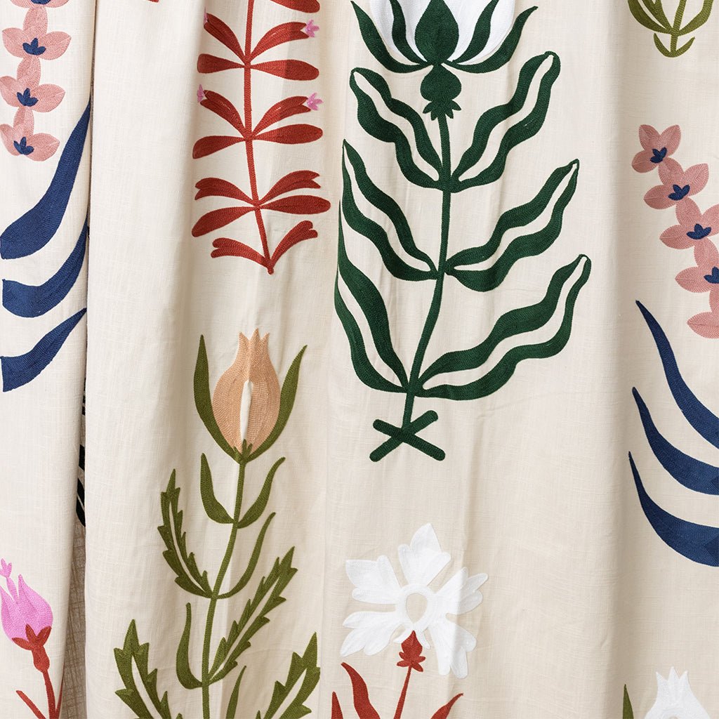 Close-up of a curtain with colorful floral and leaf patterns on a beige background
