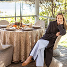 Woman sitting at a table set for a meal outdoors with a scenic background