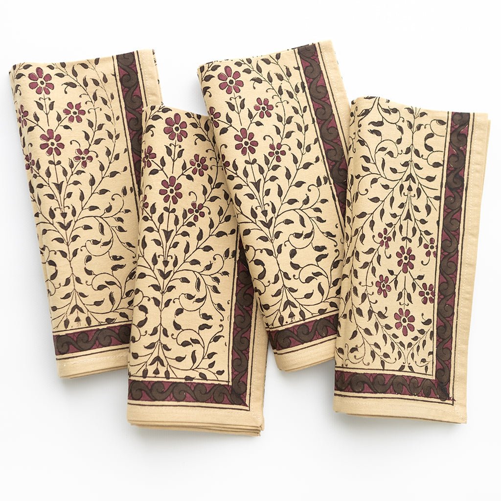 Set of four folded towels with floral pattern on a white background