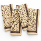 Set of four folded towels with floral pattern on a white background