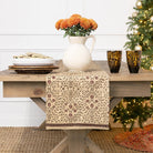 Decorative table setting with a pitcher, glasses, and floral arrangement in a home setting.