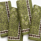Set of green fabric swatches with floral and leaf patterns on a white background