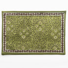 Green fabric with floral pattern and brown border on a white background