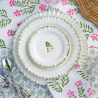 White plates with green floral patterns on a floral tablecloth