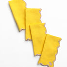 Set of yellow napkins with scalloped edges on a white background