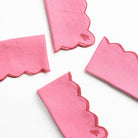 Set of pink napkins with scalloped edges on a white background