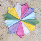 Colorful napkins arranged in a circular pattern on a textured surface.