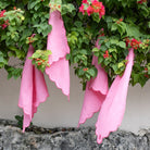 Pink linen napkins hanging in an outdoor setting.