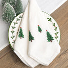 White napkins with Christmas tree design on a wooden surface