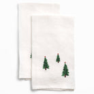 White tea towels with embroidered Christmas tree designs on a white background