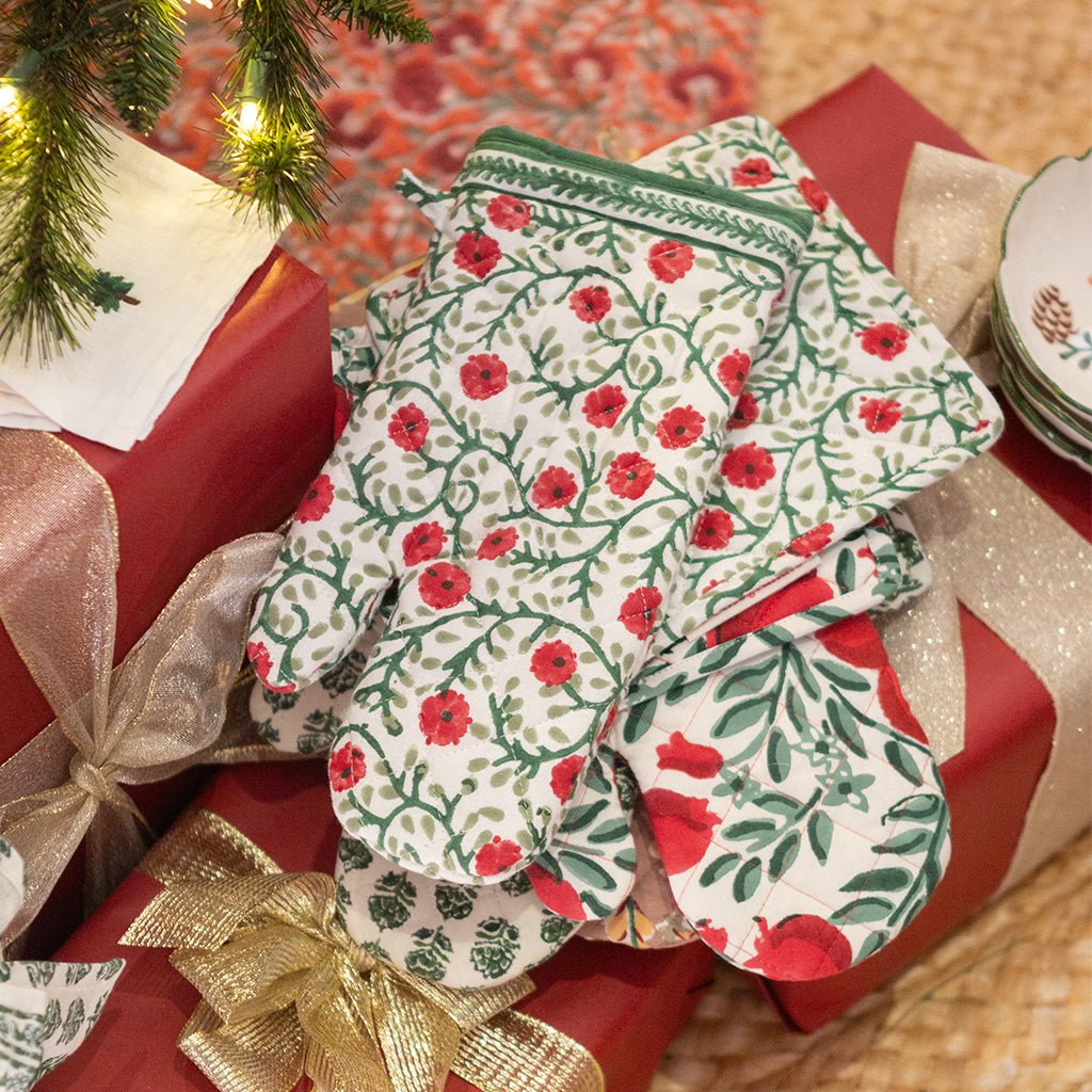 Set of floral-patterned coasters on a gift box with Christmas tree and presents in the background