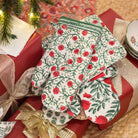Set of floral-patterned coasters on a gift box with Christmas tree and presents in the background