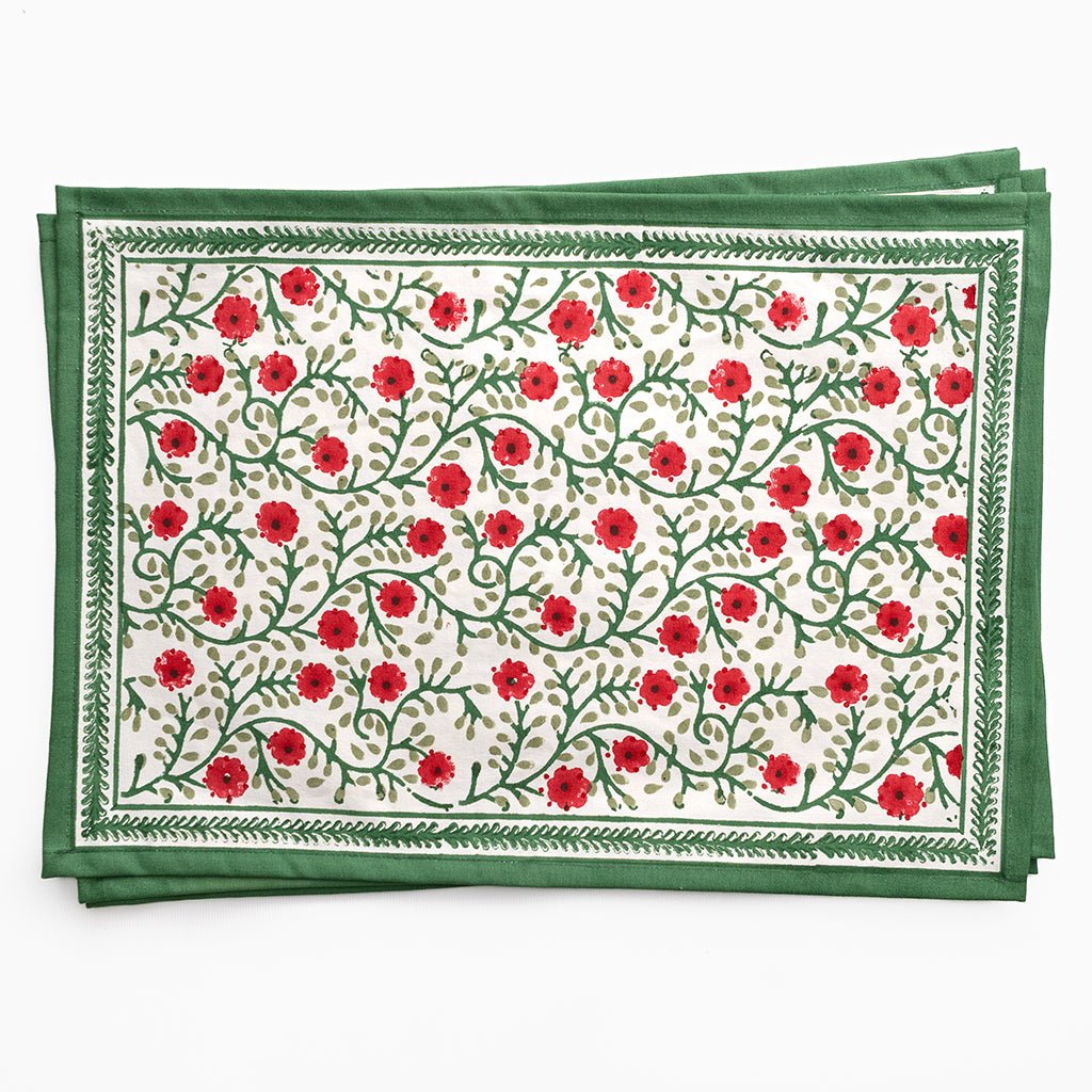 Set of two floral placemats with red flowers and green leaves on a white background
