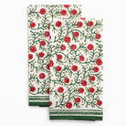 Two floral patterned towels with red flowers and green leaves on a white background