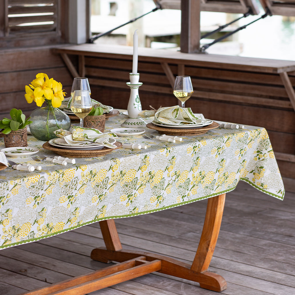 Dining table set with a floral tablecloth on a wooden deck