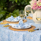 Outdoor table setting with floral decorations and white wine glasses.