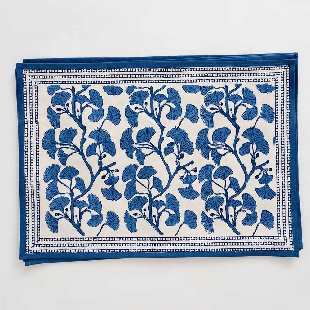 Fan shaped blue ginkgo leaf pattern placemat with blue border. 