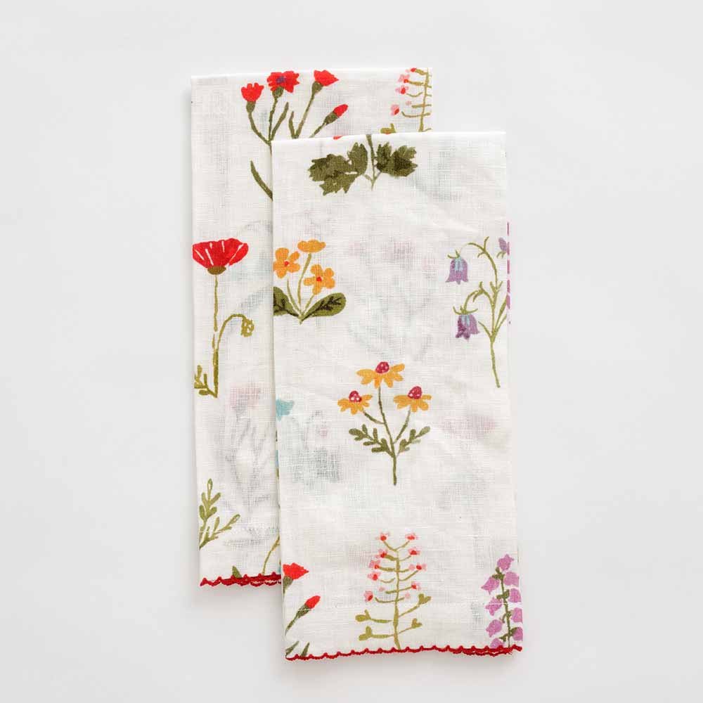 Linen fingertip towels with floral design and red scalloped stitch. 