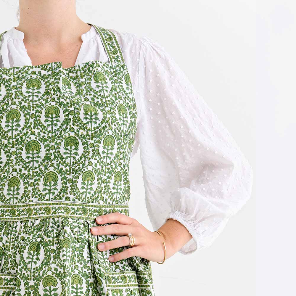 Caroline Green apron consisting of intricate green and white details. 