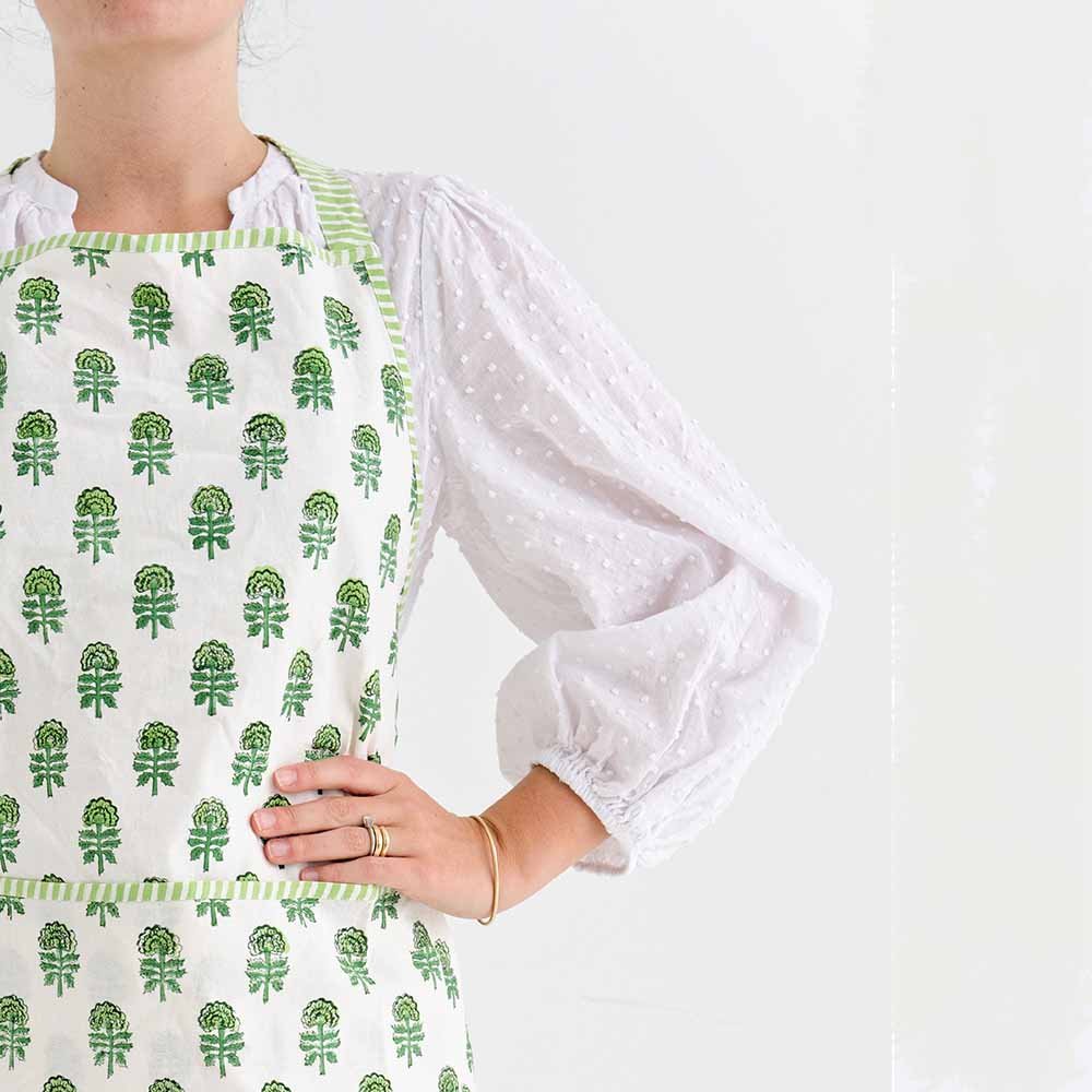 Green and white hand block printed cotton apron, edged with striped trim. 