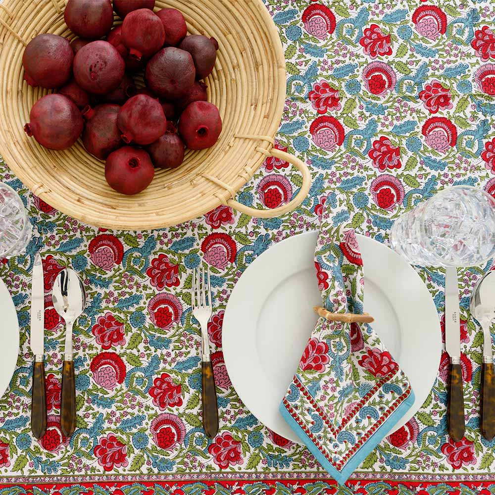Tablecloth complimented with basket of pomegranates. 