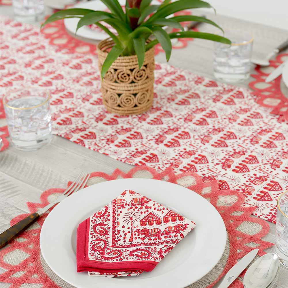 Close up of table runner with red and white elephant design. 