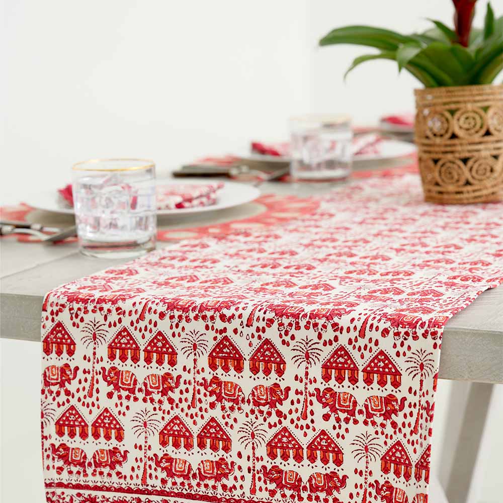 Close up of table runner with red and white elephant design. 