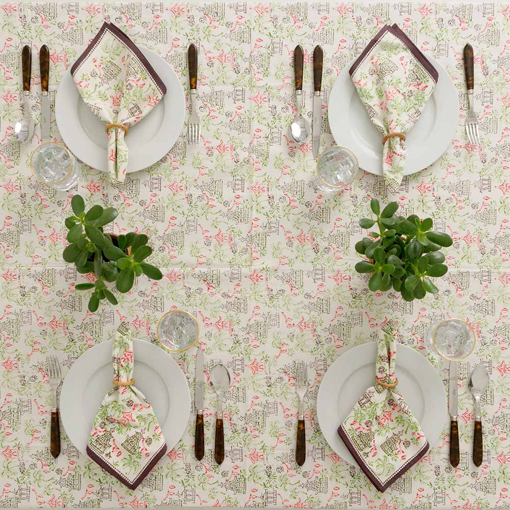 Tablecloth with matching napkins on white plates. 