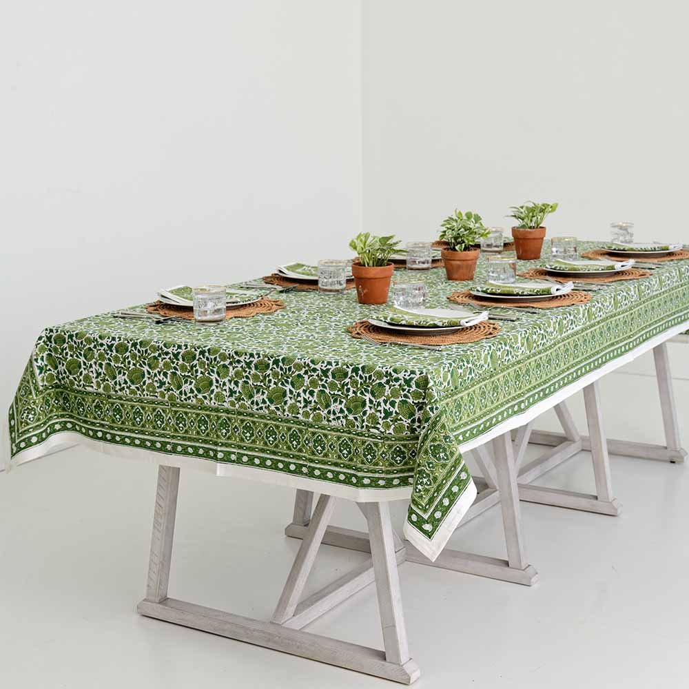 Full table view of dinner table with Jade Blossom table cloth and matching napkins with plants. 
