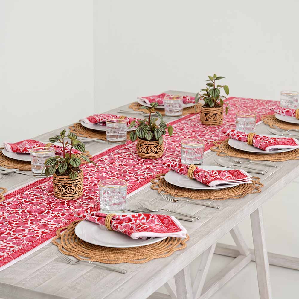 Crimson Blossom table runner paired with matching napkins on a dinner table. 