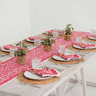 Crimson Blossom table runner paired with matching napkins on a dinner table. 