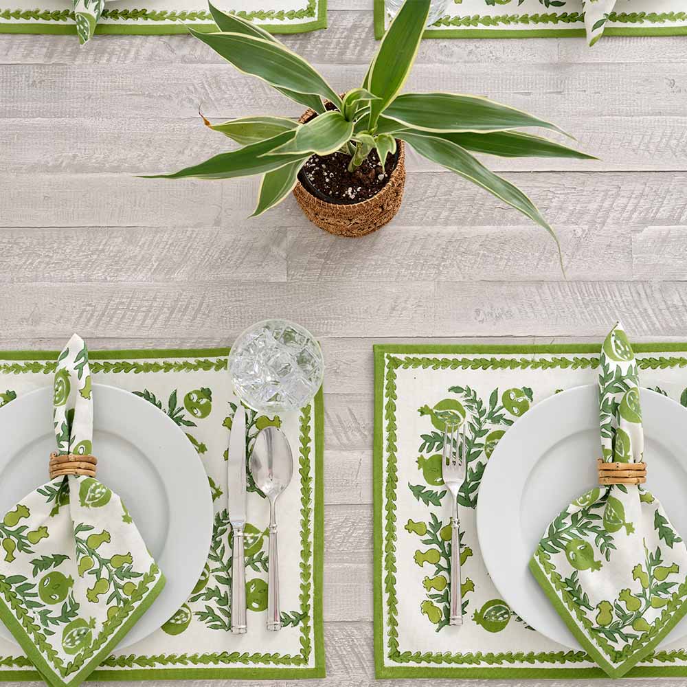 Placemats complimented with matching napkins and green plant. 