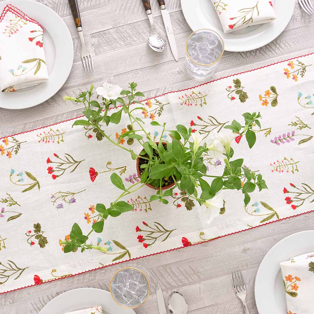 Linen table runner with greenery residing. 