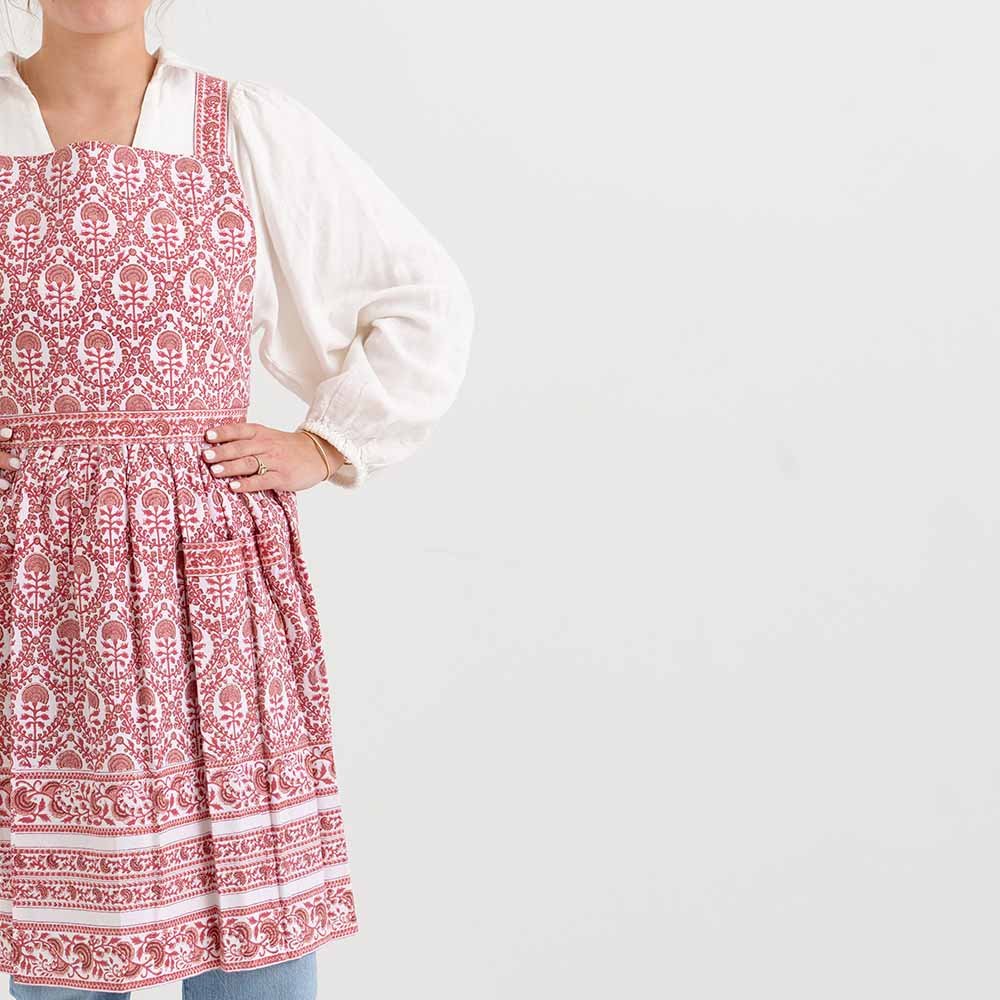 Red and white intricate details encompass this 100% cotton pleated apron. 