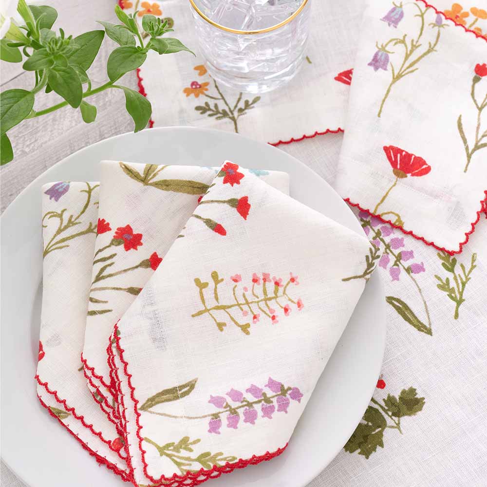 Linen napkin set with red poppy flowers, mini yellow daffodils, and lavender bluebells. 