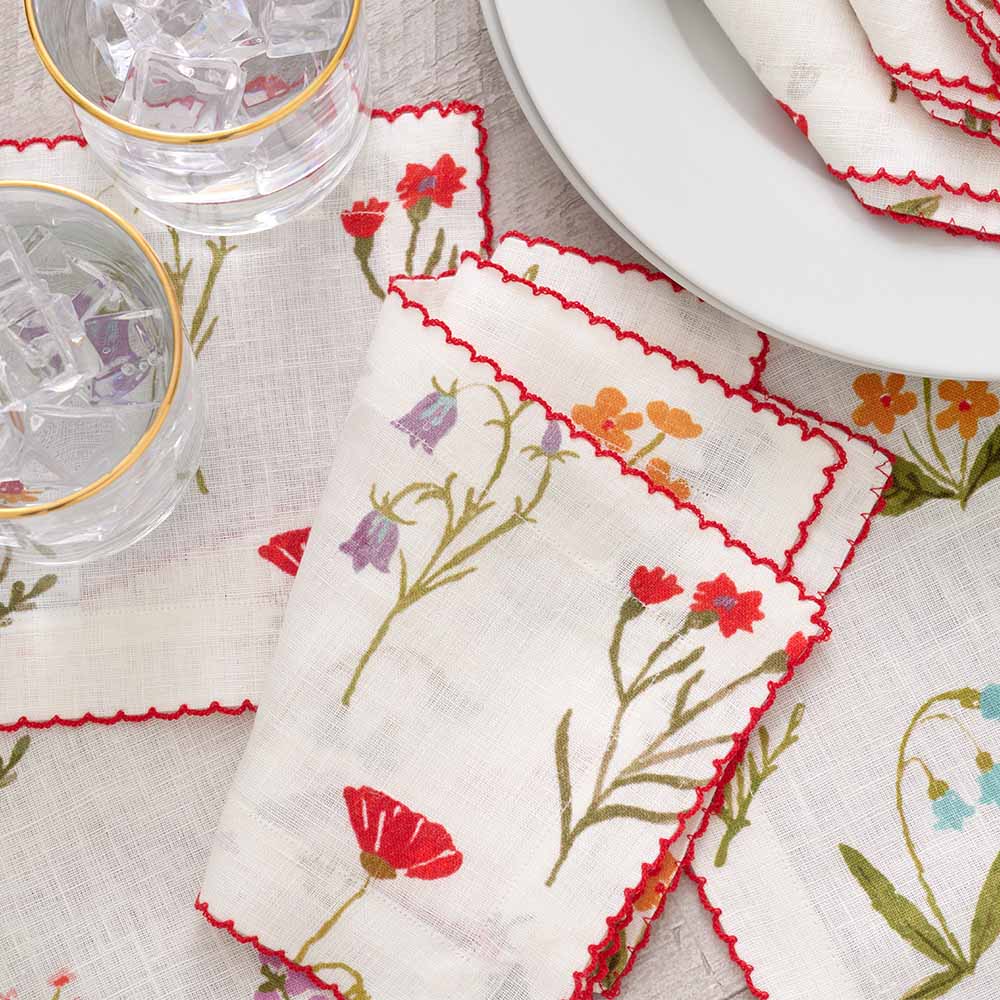 Fresh and organic floral linen napkin with red scalloped stitch. 
