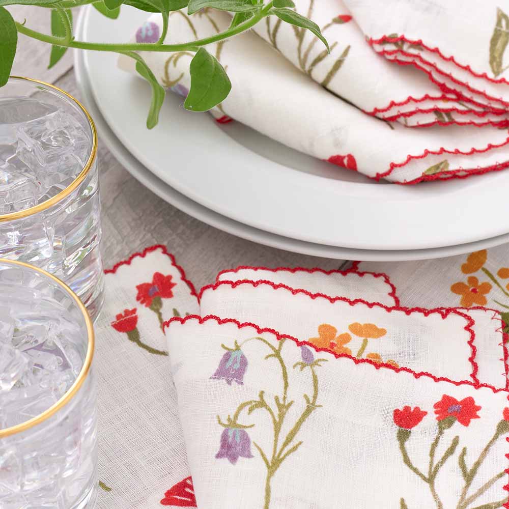 Floral napkin set with red scalloped stitch. 