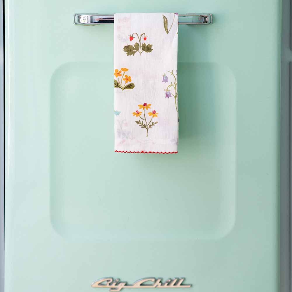 Tea towel hanging on a turquoise blue refrigerator. 