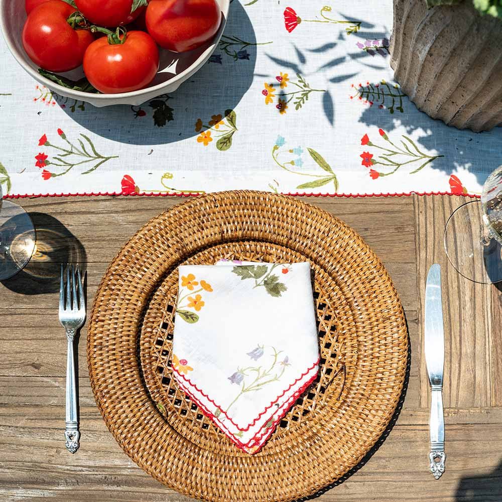 Linen napkin paired with linen table runner on an outdoor table. 